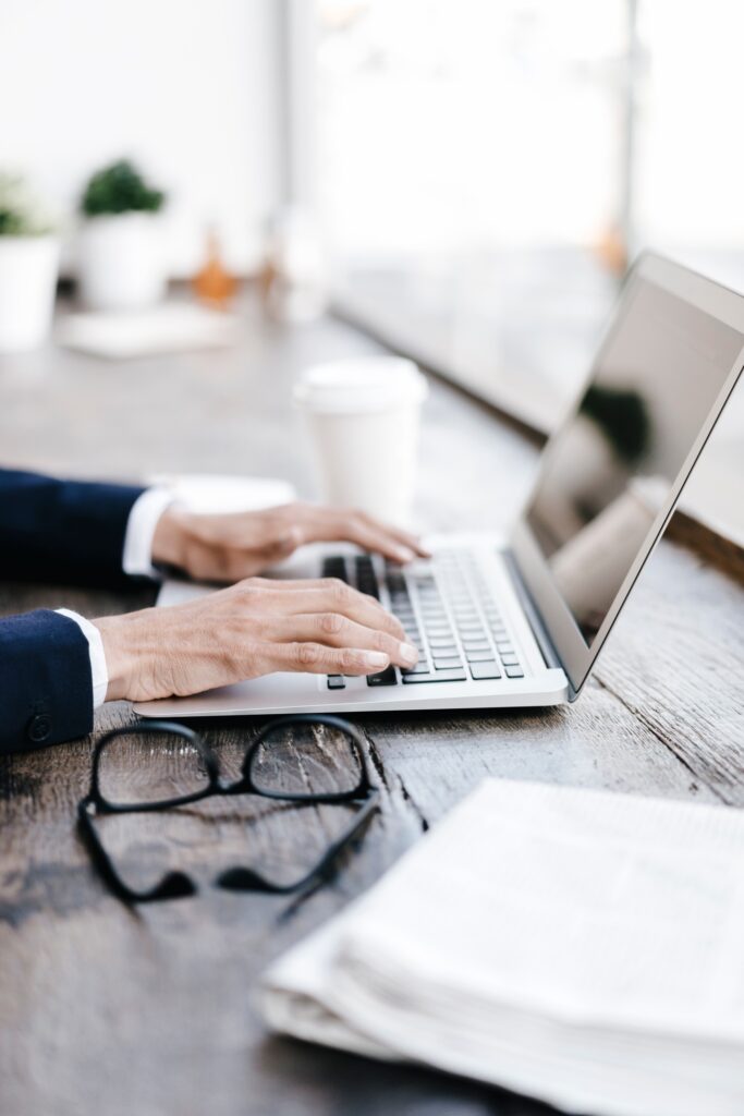 Hands of businesswoman using laptop in a cafe