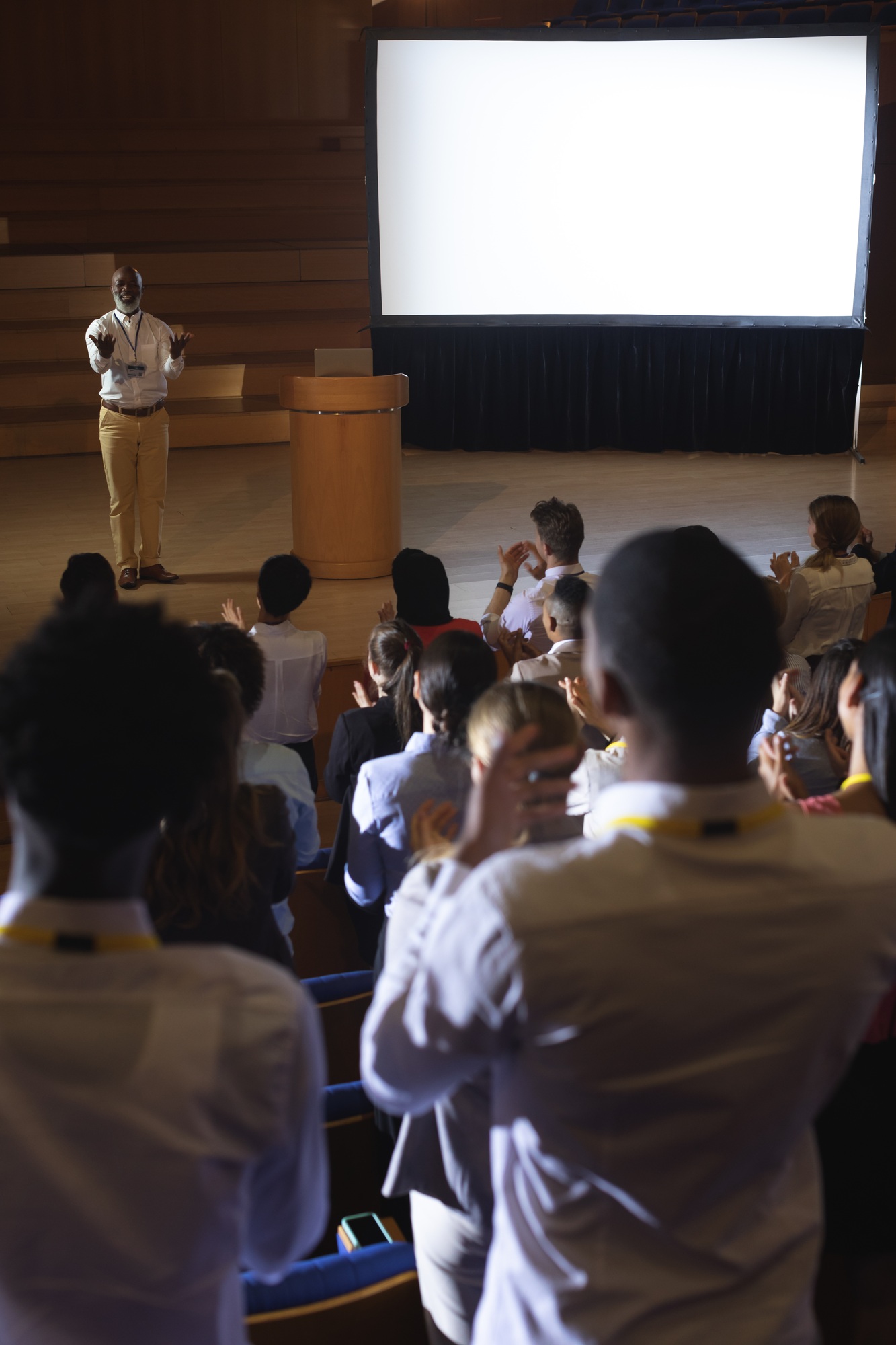 High view of matured African-American businessman standing and giving presentation in auditorium