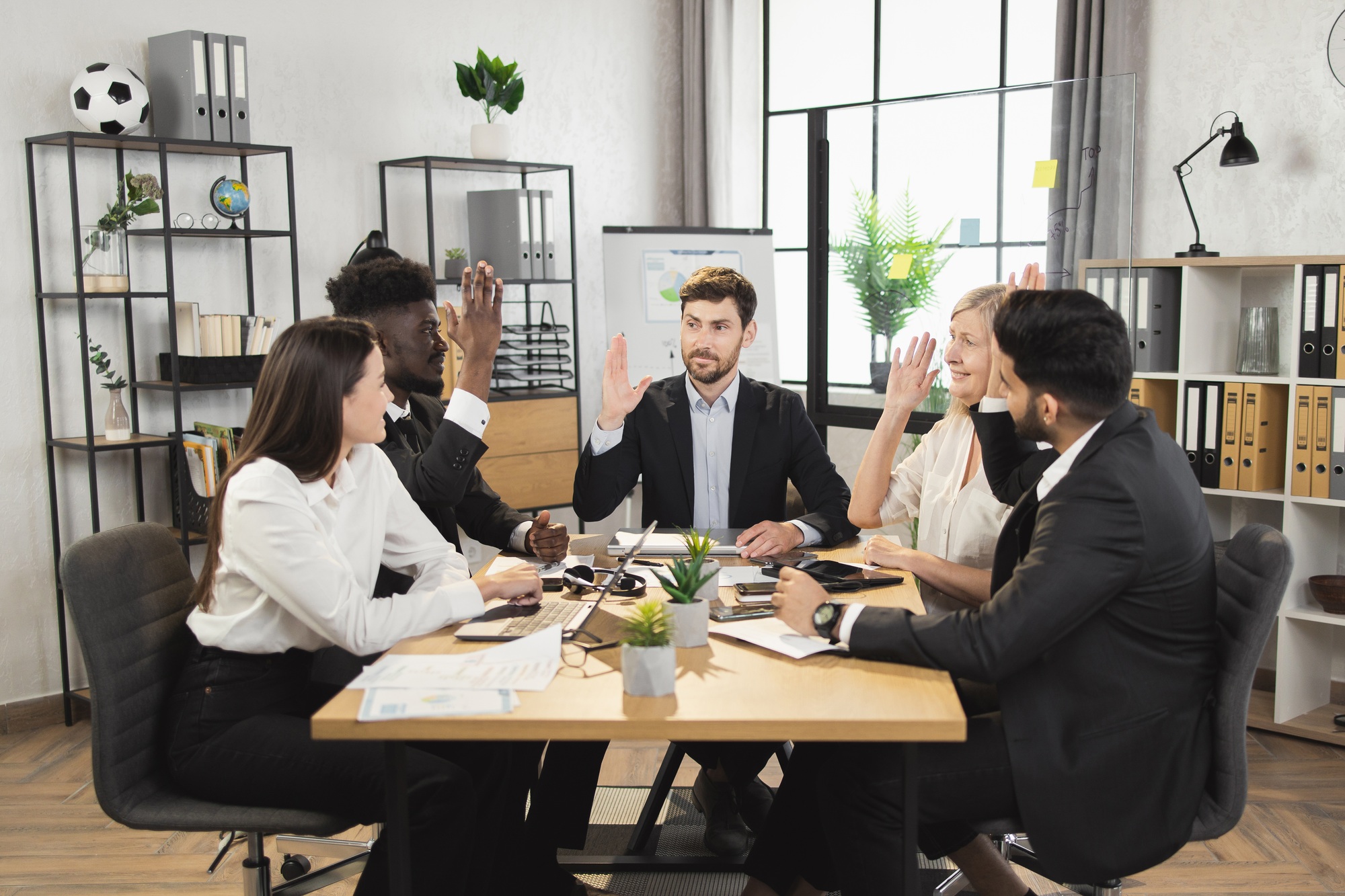 Partners raising hands while supporting business agreement