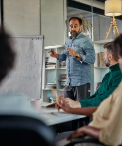 Male coach presenting business plan, strategy or new project on meeting